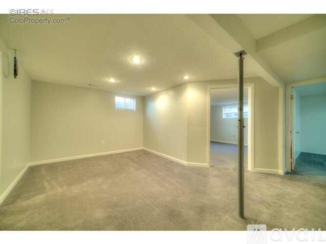 A spacious room with carpeted floor and white walls.