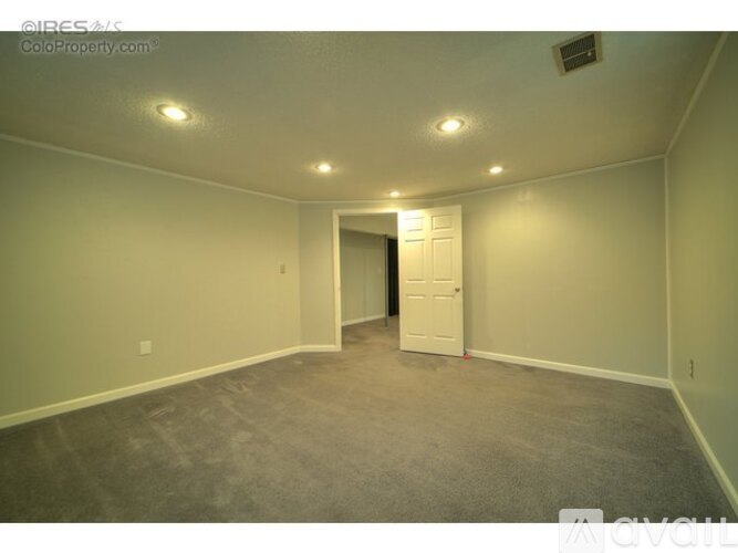 A room with a carpeted floor and a white door.