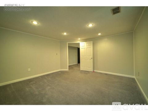 A room with a carpeted floor and a white door.