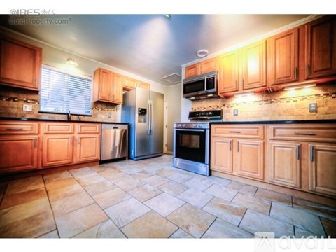 A kitchen with wooden cabinets and tile flooring.