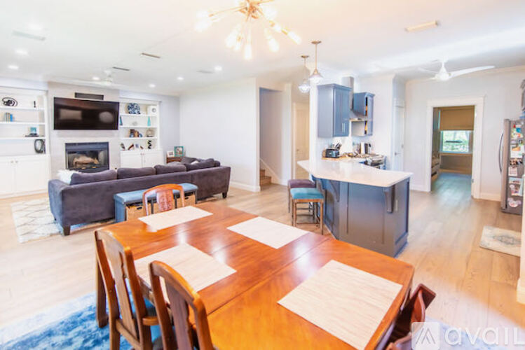 A modern open plan living and dining area with a kitchen in the background.