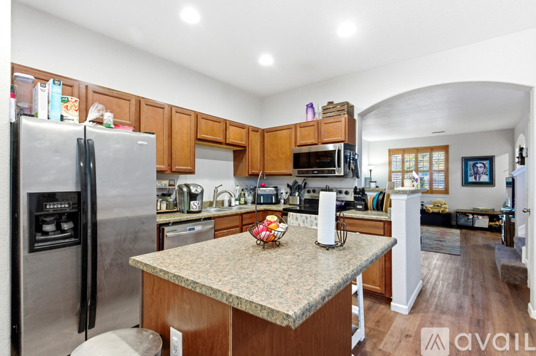 A kitchen with wooden cabinets and a granite countertop.