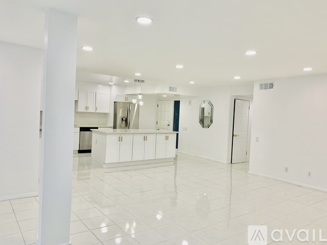A spacious kitchen with white cabinets and a large island.