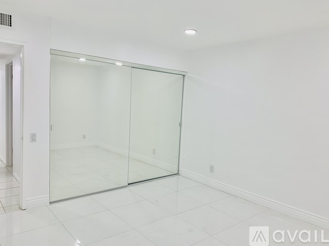 A room with a glass door and white walls.