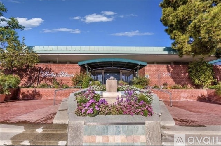 A building with a green roof and a fountain in front of it.