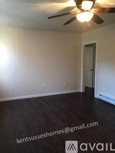 A room with a ceiling fan and a door.