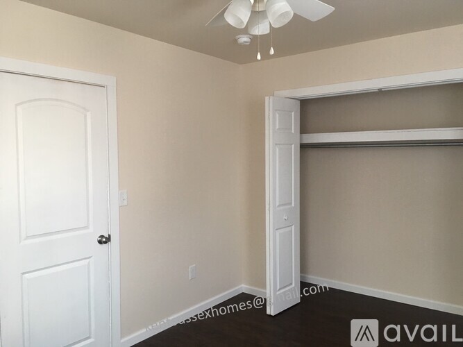 A room with a white door and a white closet with a white ceiling fan.