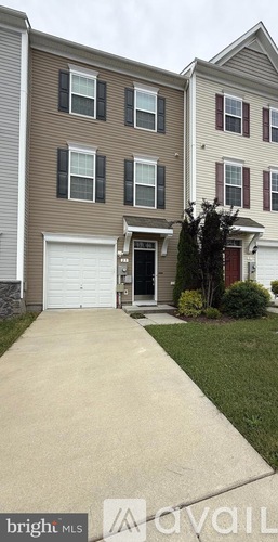 A two-story house with a garage and a driveway.