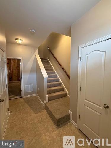 A hallway with a staircase leading to the second floor.