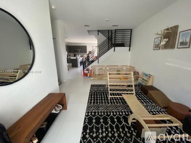 A living room with a black and white patterned rug and a wooden bench.