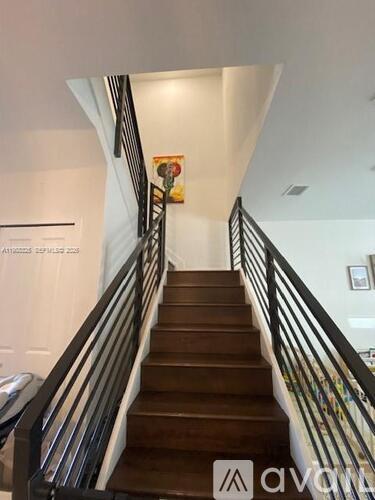 A staircase with a metal railing and wooden steps.