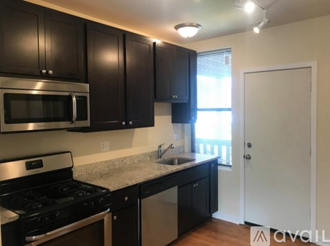 A kitchen with black cabinets and stainless steel appliances.
