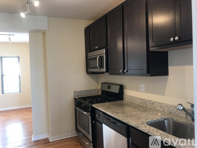 A kitchen with black cabinets and a granite countertop.