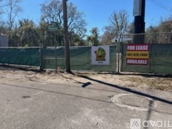 A sign on a fence says "FOR LEASE AVAILABLE".
