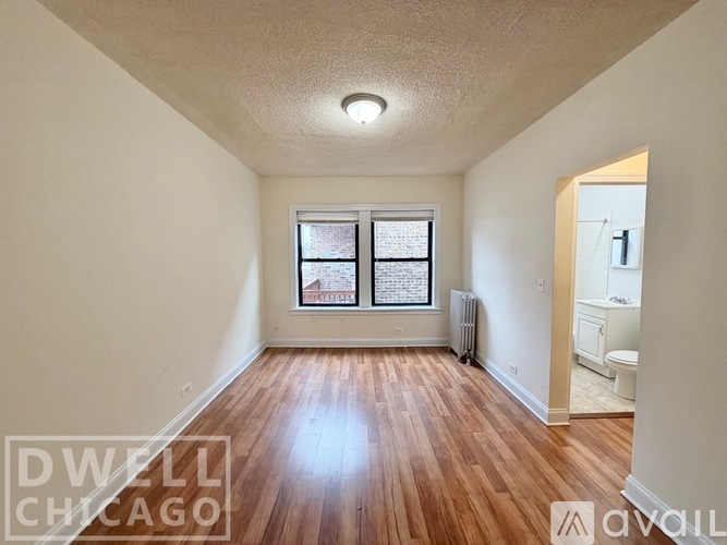 A room with a window and a radiator on the wall.