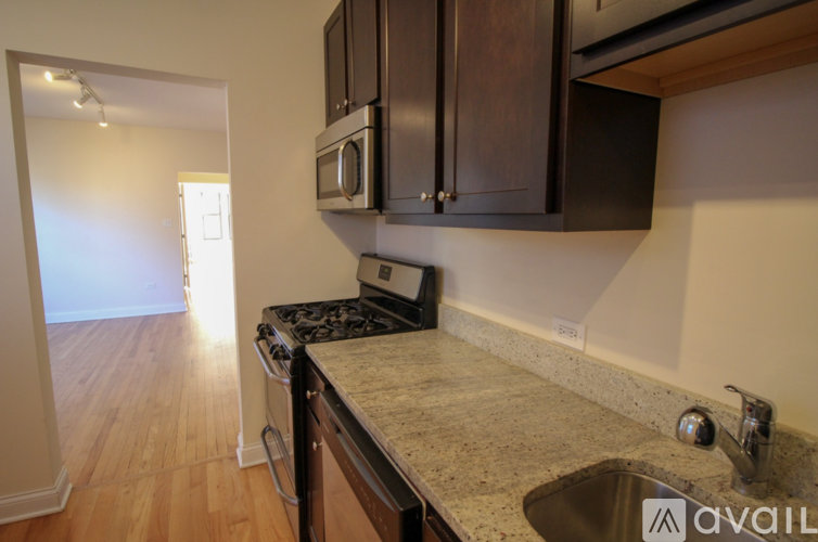 A kitchen with a sink, stove, and microwave.