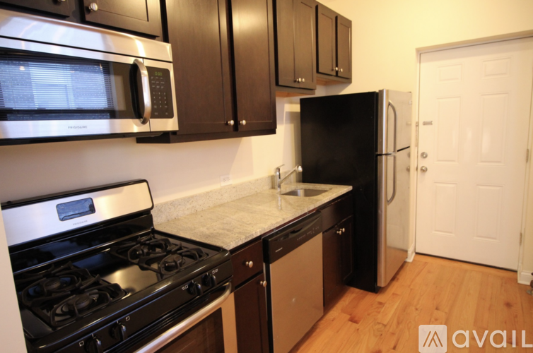 A kitchen with black appliances and brown cabinets.