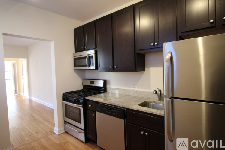 A kitchen with a stainless steel refrigerator, microwave, oven, and dishwasher.