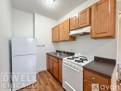 A kitchen with wooden cabinets and a white stove top oven.