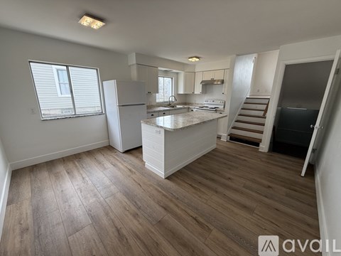 A kitchen with wooden floors and white appliances.