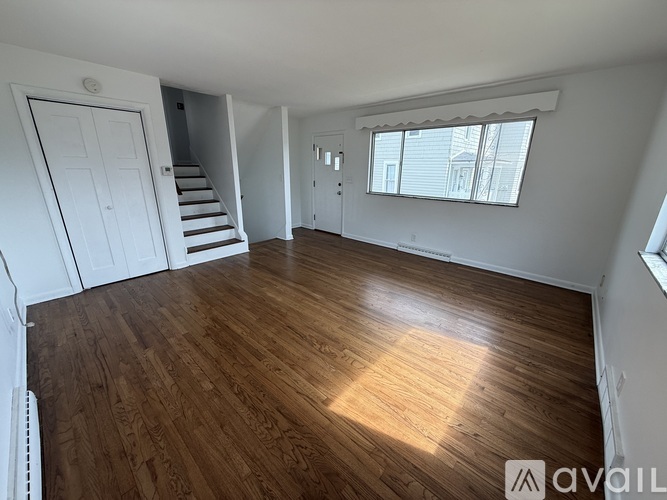 A room with wooden flooring and white walls.