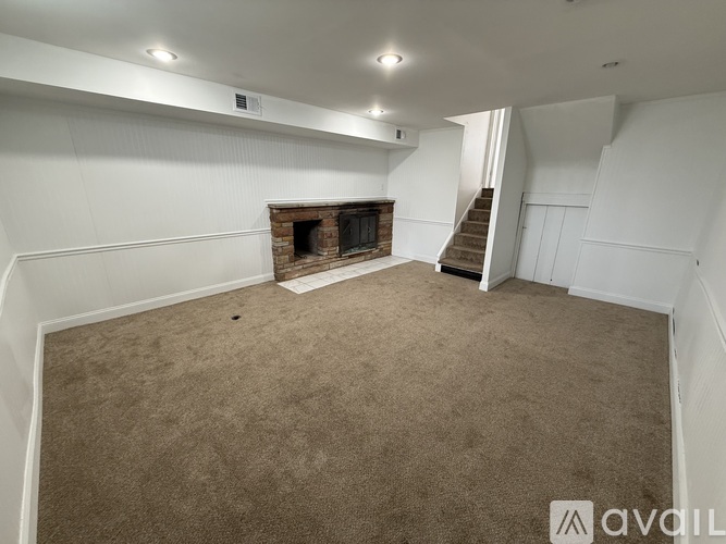 A living room with a fireplace and a staircase.