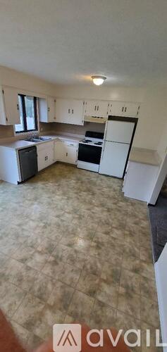 A kitchen with white cabinets and a black dishwasher.