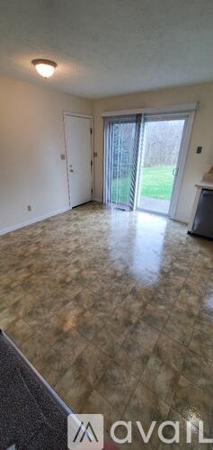 A room with a brown floor and a sliding glass door.