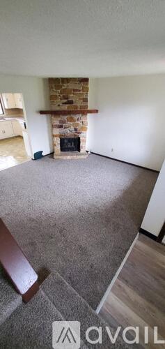 A living room with a fireplace and a carpeted floor.