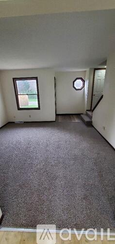 A room with a carpeted floor and a window.