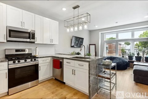 A modern kitchen with white cabinets and stainless steel appliances.