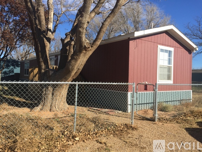 A red house with a tree in front of it.