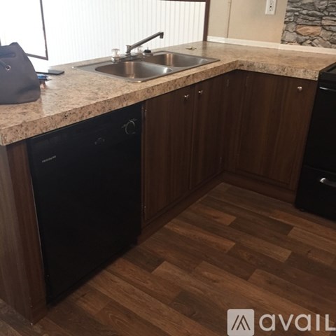 A kitchen with wooden cabinets and a granite countertop.