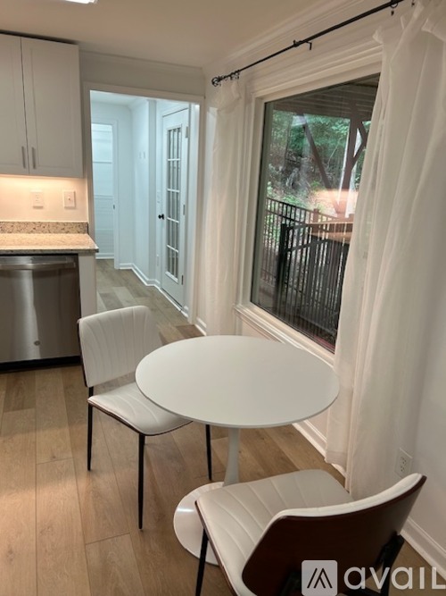 A kitchen with a table and chairs.