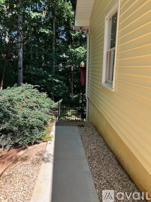A yellow house with a grey walkway leading to the door.