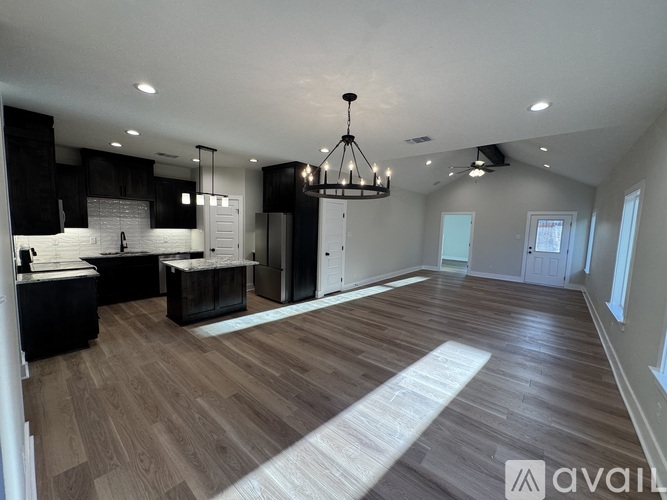 A spacious kitchen with dark wood cabinets and a white island.