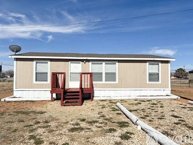 A mobile home with a brown and white exterior and a brown porch.