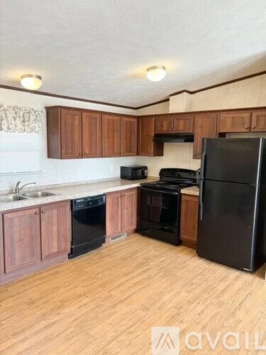 A kitchen with wooden cabinets and black appliances.