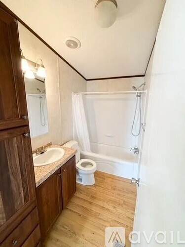 A small bathroom with a toilet, sink, and shower.