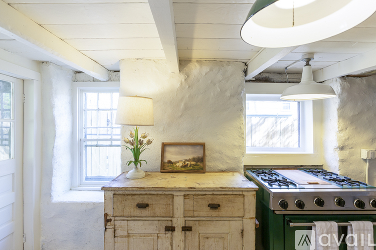 A kitchen with a green stove and wooden cabinets.