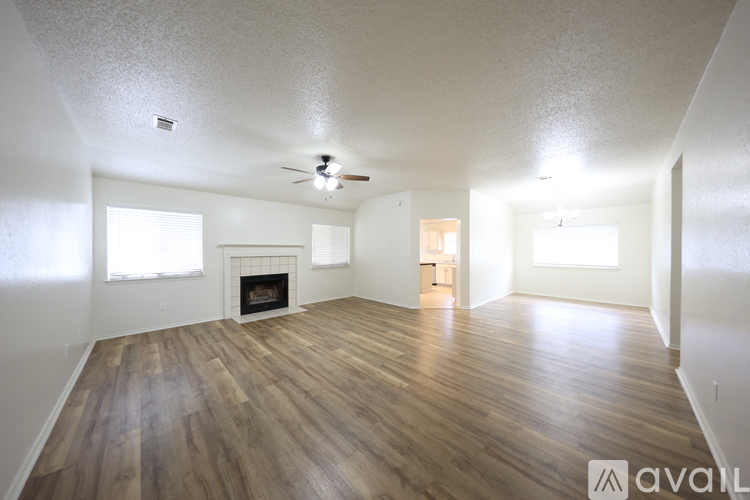 A spacious room with wooden floors and a fireplace is available for rent.