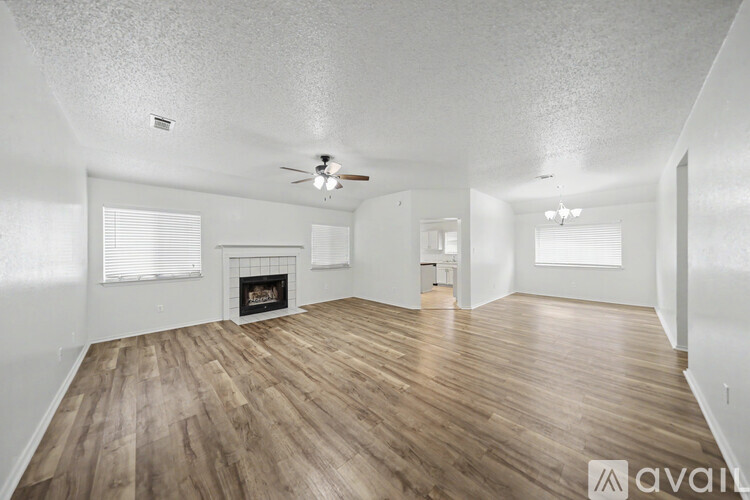 A spacious living room with wooden floors and a fireplace.