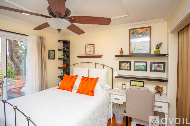 A bedroom with a bed, desk, and chair.