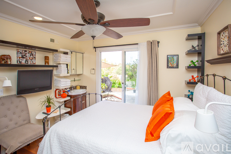 A bedroom with a large bed and a ceiling fan.