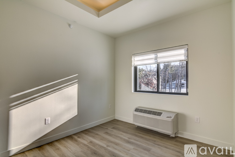 A room with a window and a wall-mounted air conditioner unit.