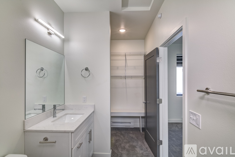 A bathroom with a sink, mirror, and a walk-in shower.