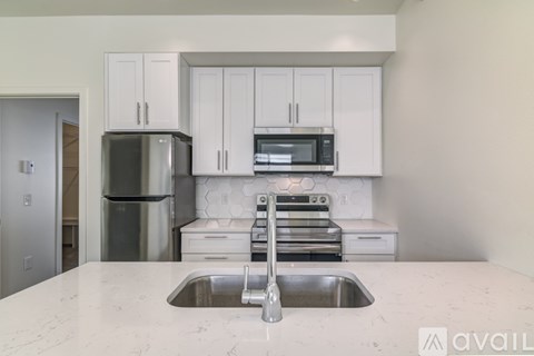 A kitchen with white cabinets and a stainless steel refrigerator.