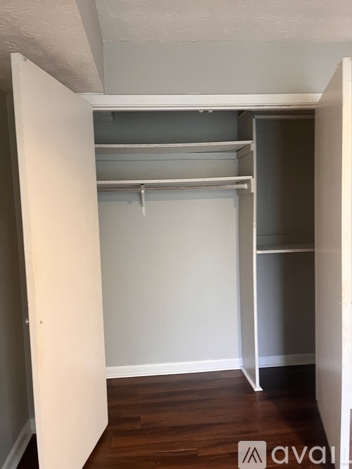 A white closet with shelves and a hanger.