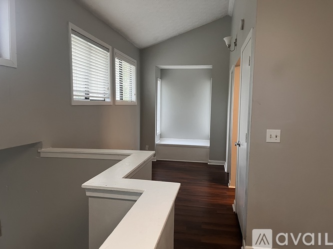 A room with a white counter and wooden floor.