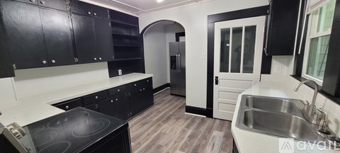 A kitchen with black cabinets and a white counter top.